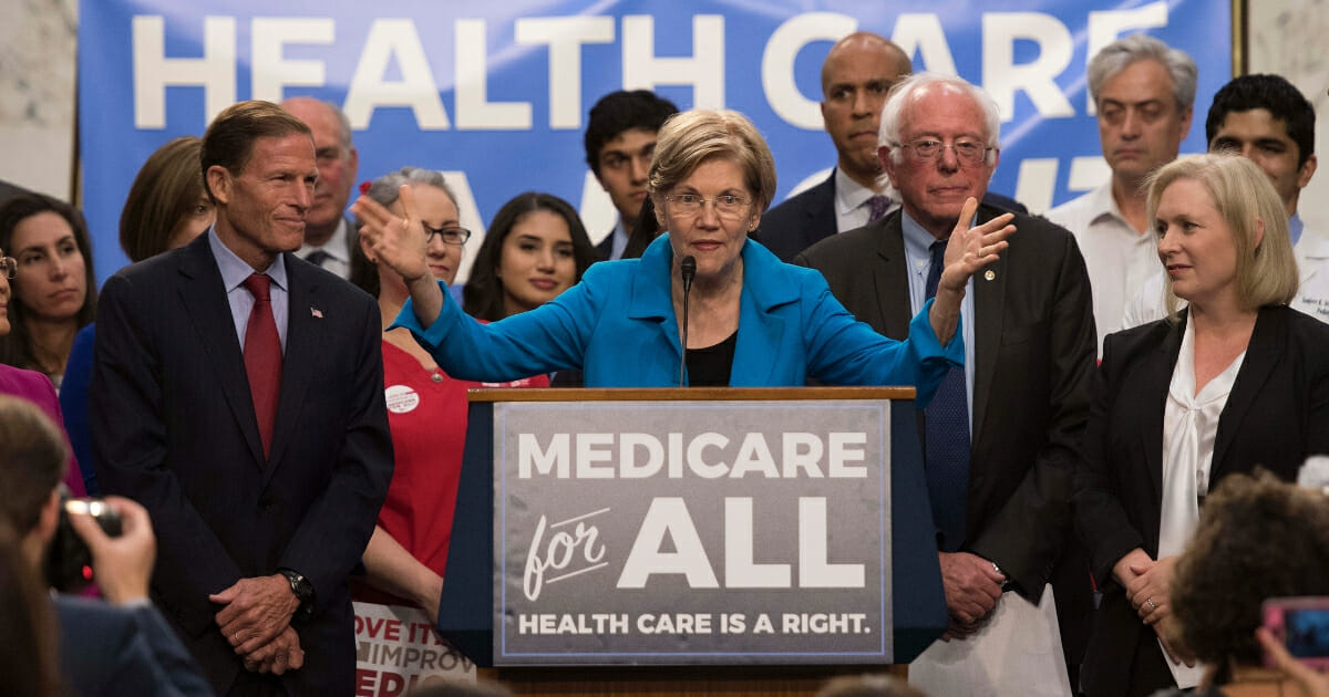 Senator Elizabeth Warren center, a Democrat from Massachusetts, speaks with Senator Bernie Sanders, second from the right, of Vermont as they discusses Medicare for All legislation on Capitol Hill in Washington, D.C., on Sept. 13, 2017.