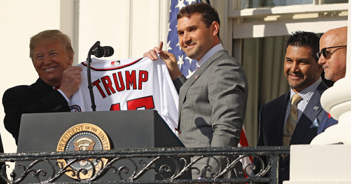 Washington Nationals first baseman Ryan Zimmerman presents President Donald Trump with a team jersey during a celebration of the 2019 World Series champions at the White House on Nov. 4, 2019, in Washington, D.C.