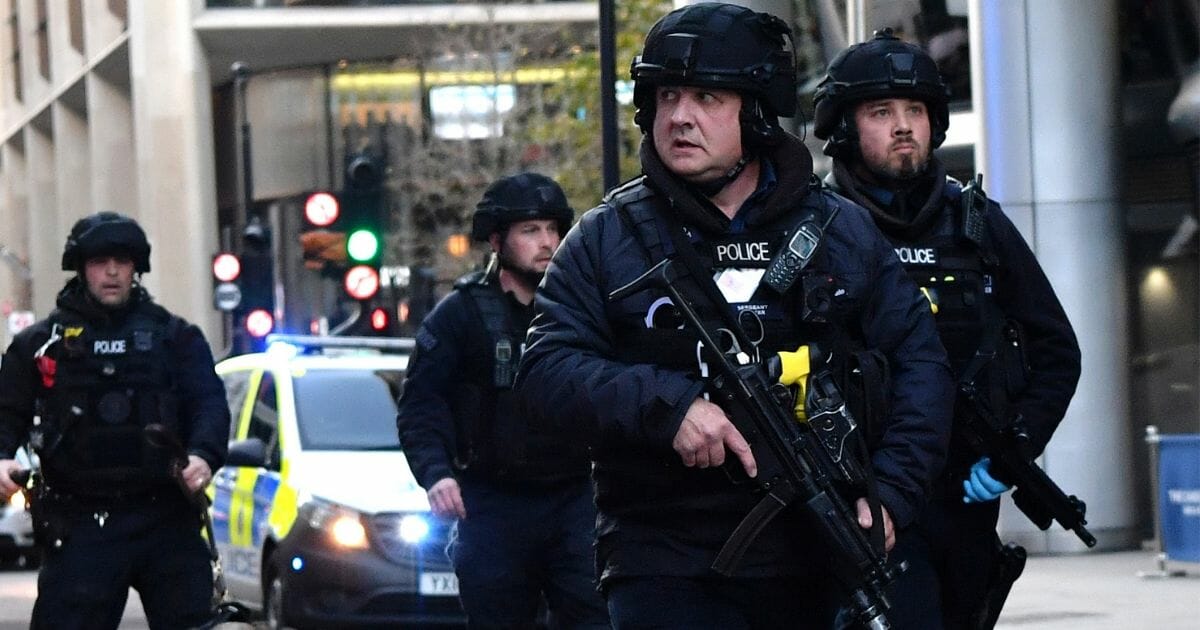 Armed police with dogs patrol along Cannon Street in central London, on Nov. 29, 2019, after reports of an attack on London Bridge.