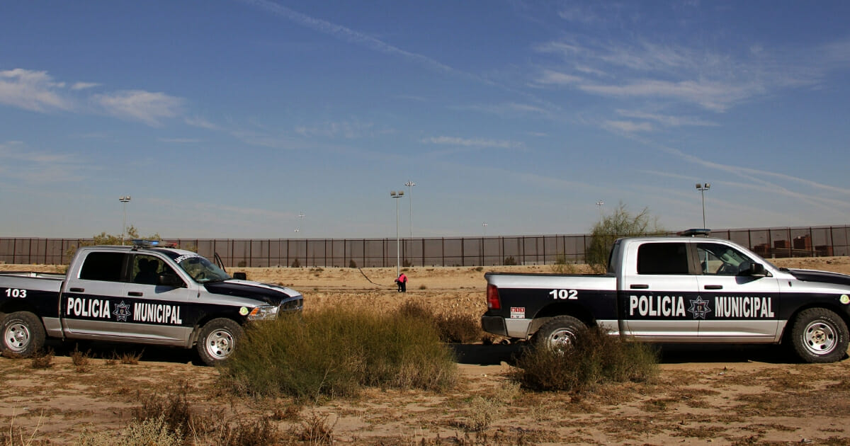 Mexican police vehicles are seen on the banks of the Rio Grande near Ciudad Juarez, in the state of Chihuahua, Mexico, as Central American migrants wait on the U.S. side, allegedly to request political asylum once detained by the United States Border Patrol, on Nov. 16, 2018.