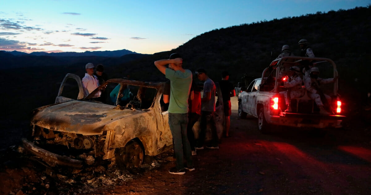 Members of the LeBaron family look at the burned car where some of their relatives were killed during an ambush Nov. 5, 2019, in the Sonora mountains of Mexico.