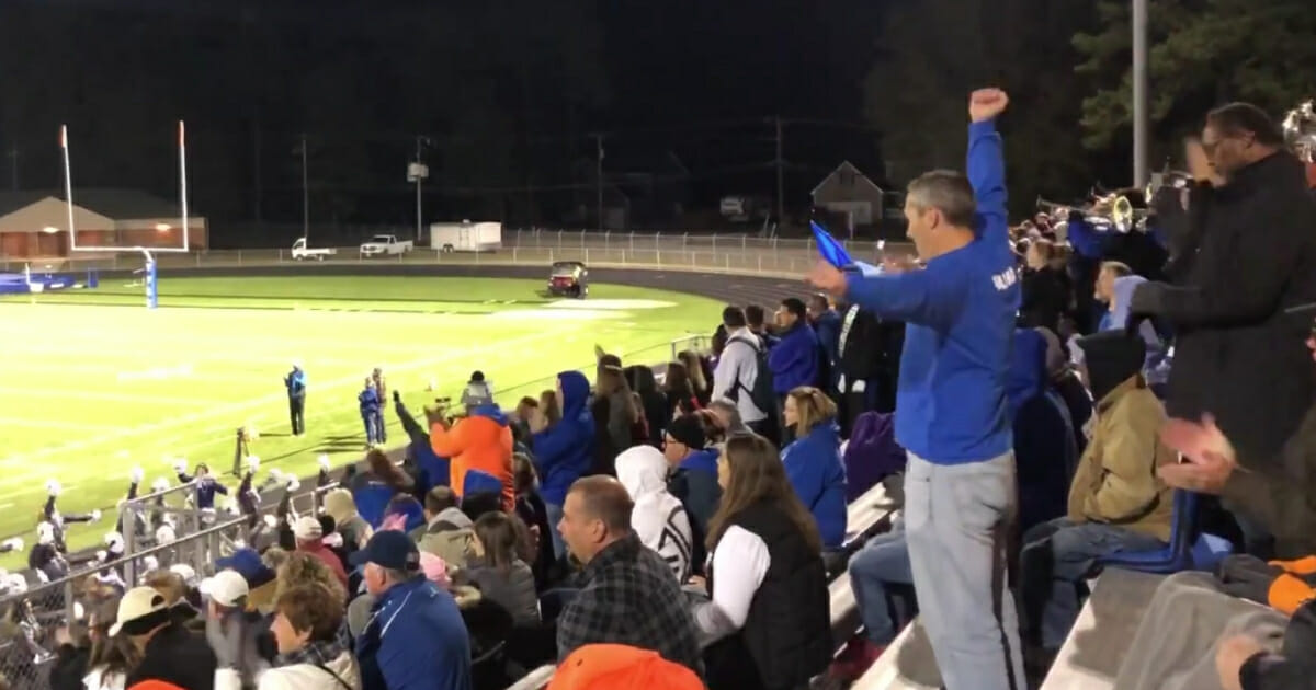 A video of a Virginia dad performing his high school daughter's cheer routine from the stands has gone viral, bringing a little bit of joy to a community that's currently mourning the loss of three of its own.