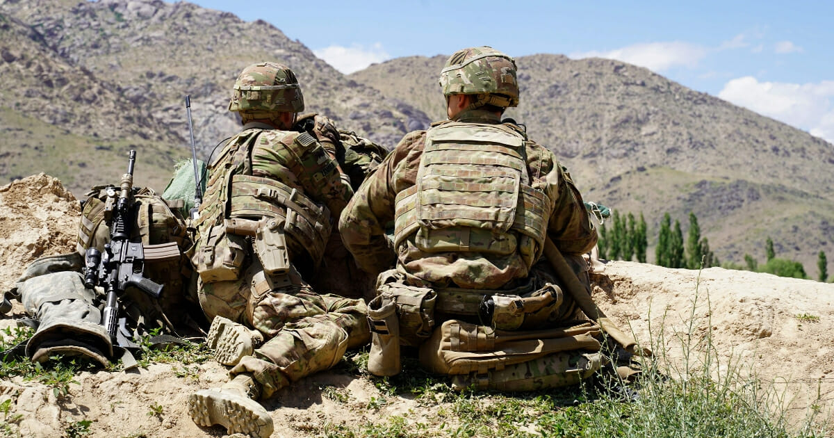 U.S. soldiers look out over the Afghan hillsides at a checkpoint in Nerkh district of Wardak province on June 6, 2019.