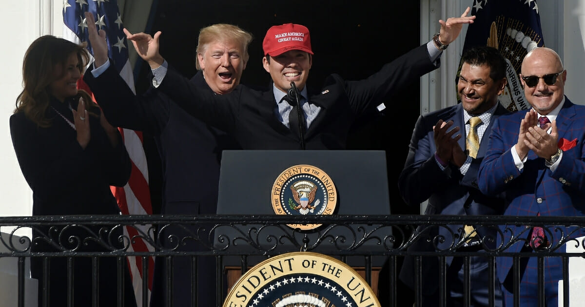 President Donald Trump smiles as Washington Nationals catcher Kurt Suzuki wears a "Make America Great Again" hat during a ceremony to honor the World Series champions Nov. 4, 2019, at the White House.