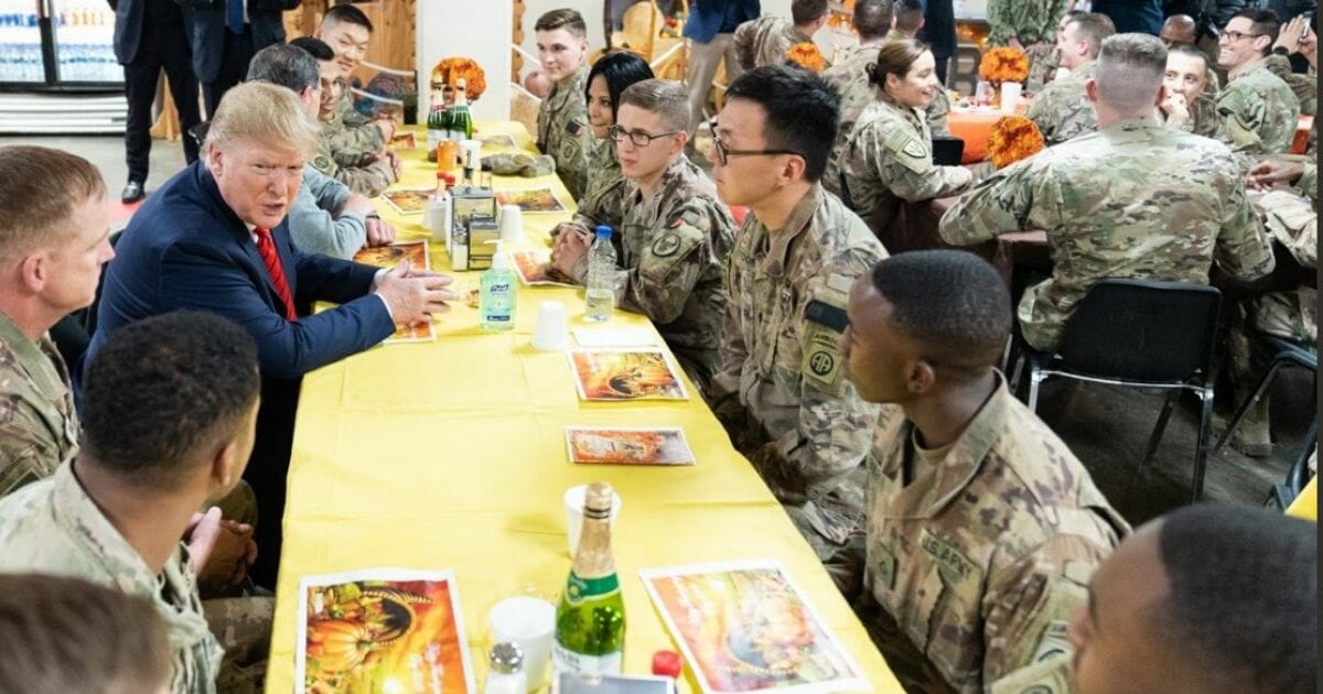 Donald Trump sitting with troops