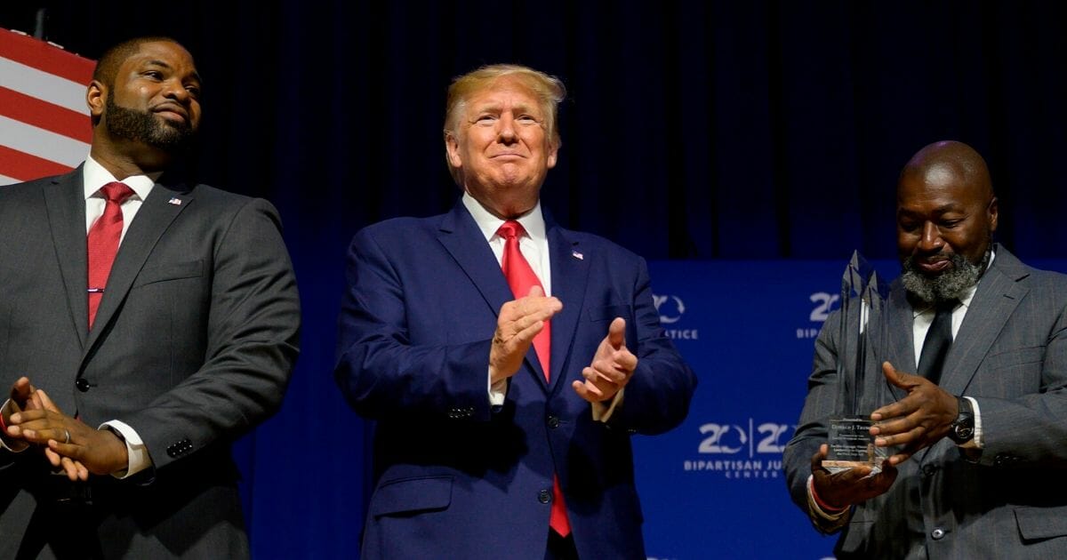 President Donald Trump applauds before being awarded the Bipartisan Justice Award by ex-convict Matthew Charles, right, who was released from federal prison through the First Step Act, at an Oct. 25 ceremony in Columbia, South Carolina.
