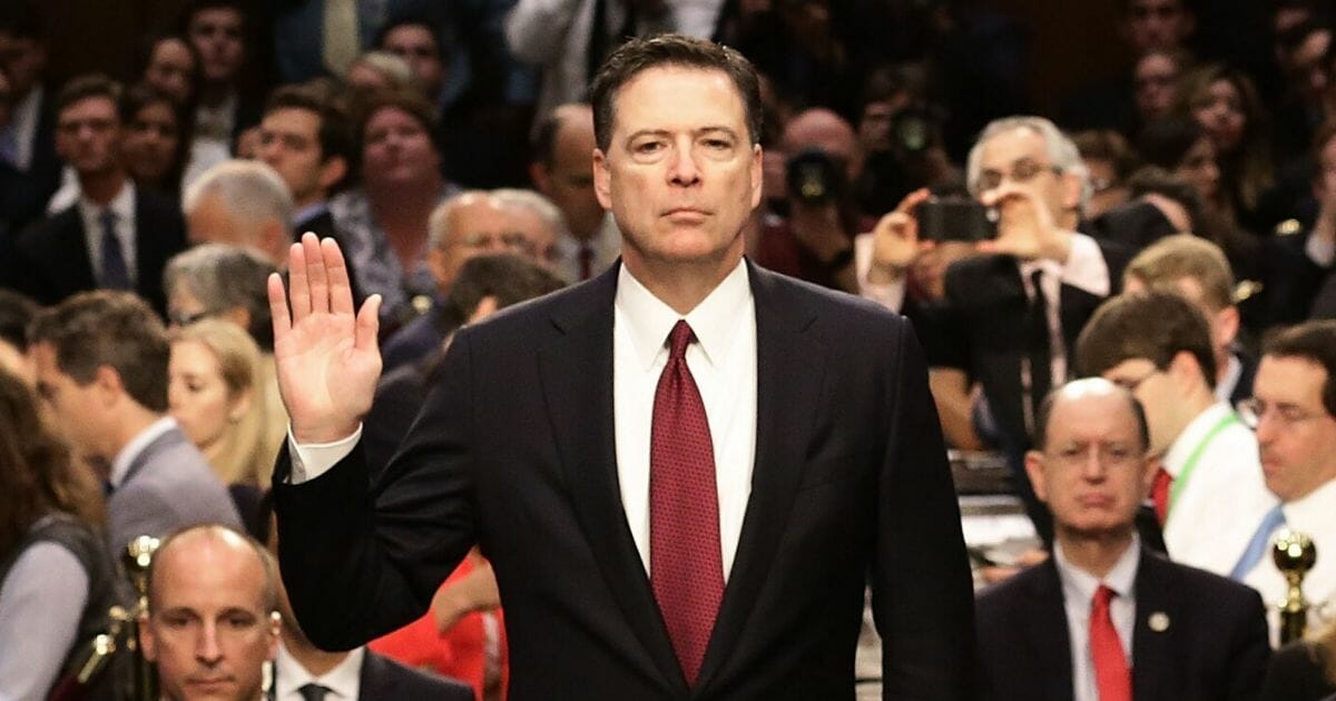 Former FBI Director James Comey is sworn in before testifying before the Senate Intelligence Committee in June 2017, a month after being fired by President Donald Trump.
