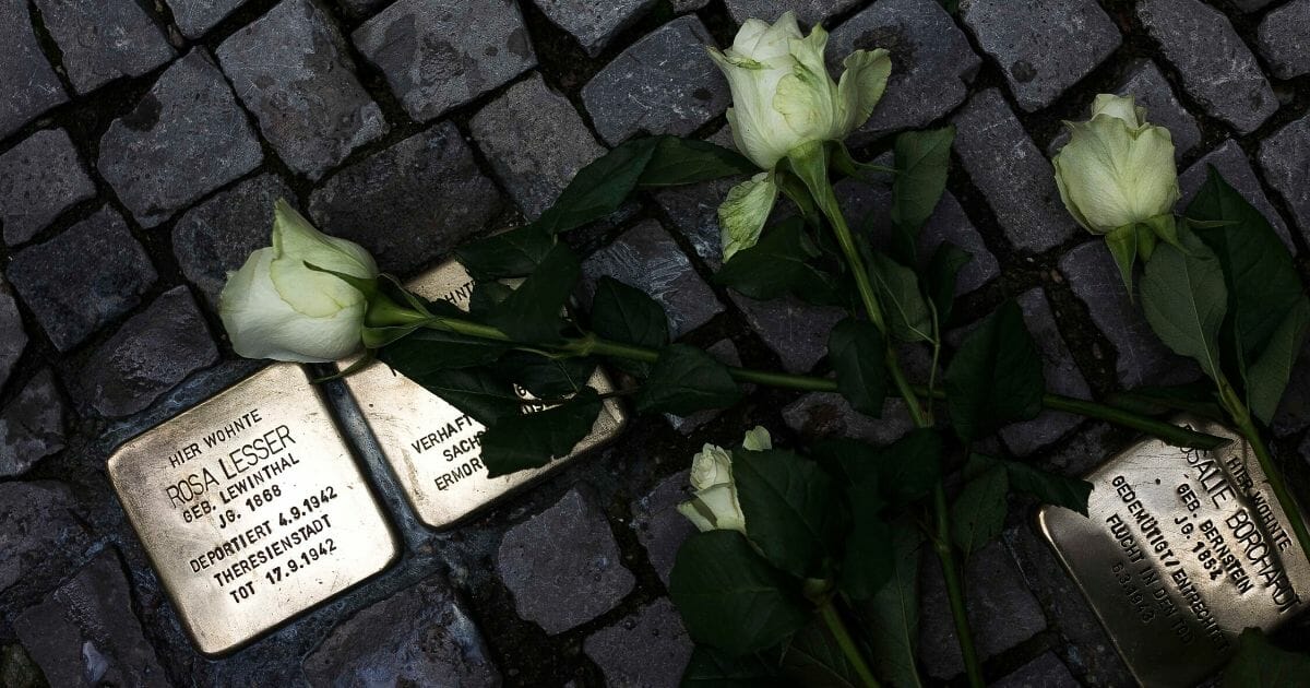 Roses lie on the ground between so-called Stolpersteine, brass stumbling blocks, to commemorate the 75th anniversary of the Kristallnacht pogroms on November 9, 2013, in Berlin.
