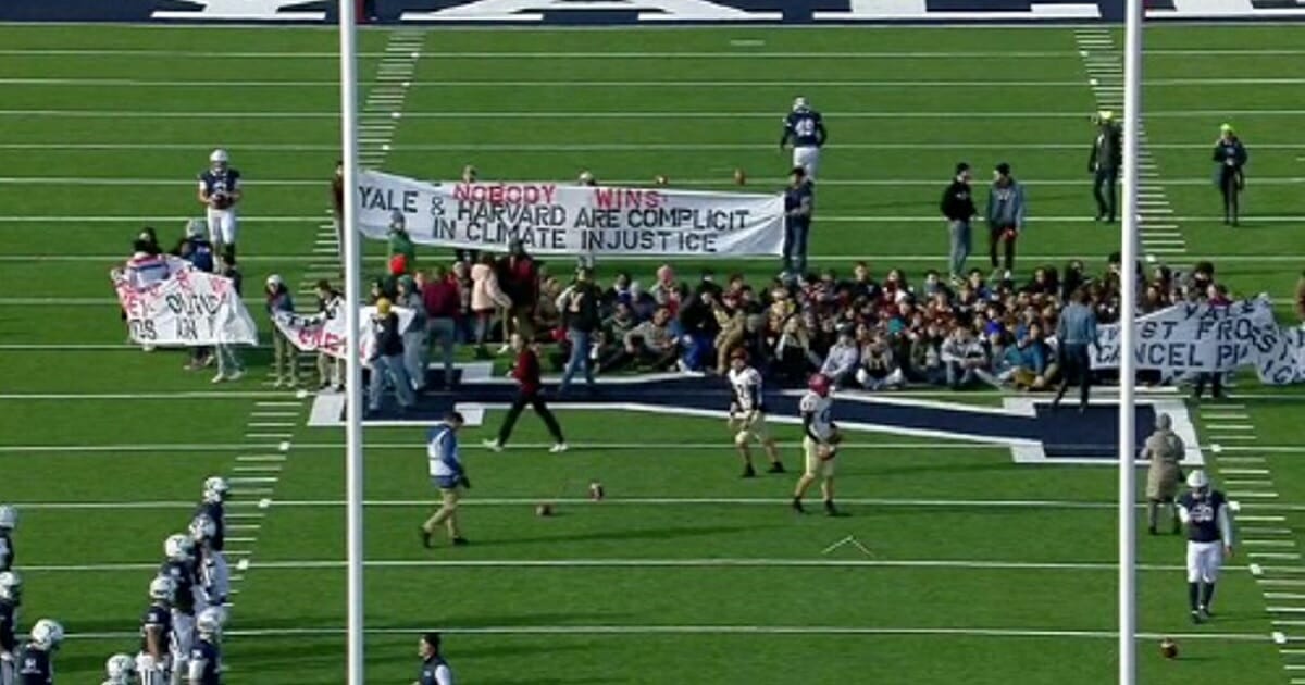 Climate protesters take the field during Saturday's Harvard-Yale football game.