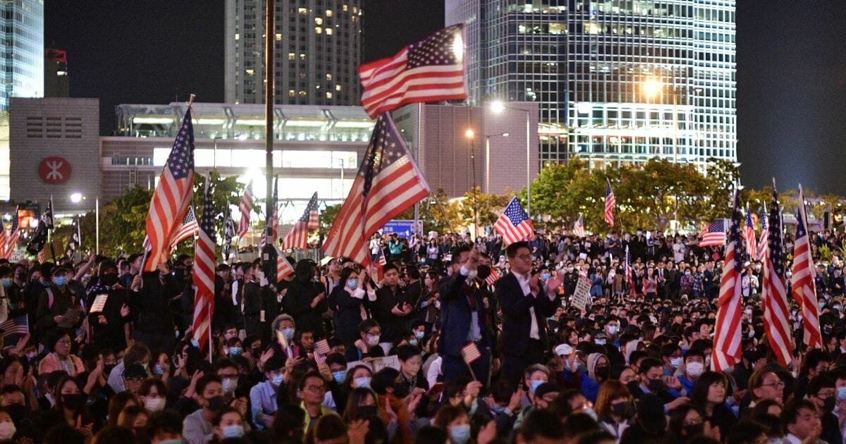 People hold up U.S. national flags during a gathering of thanks at Edinburgh Place in Hong Kong's Central district on Nov. 28, 2019, after U.S. President Donald Trump signed legislation requiring an annual review of freedoms in Hong Kong.