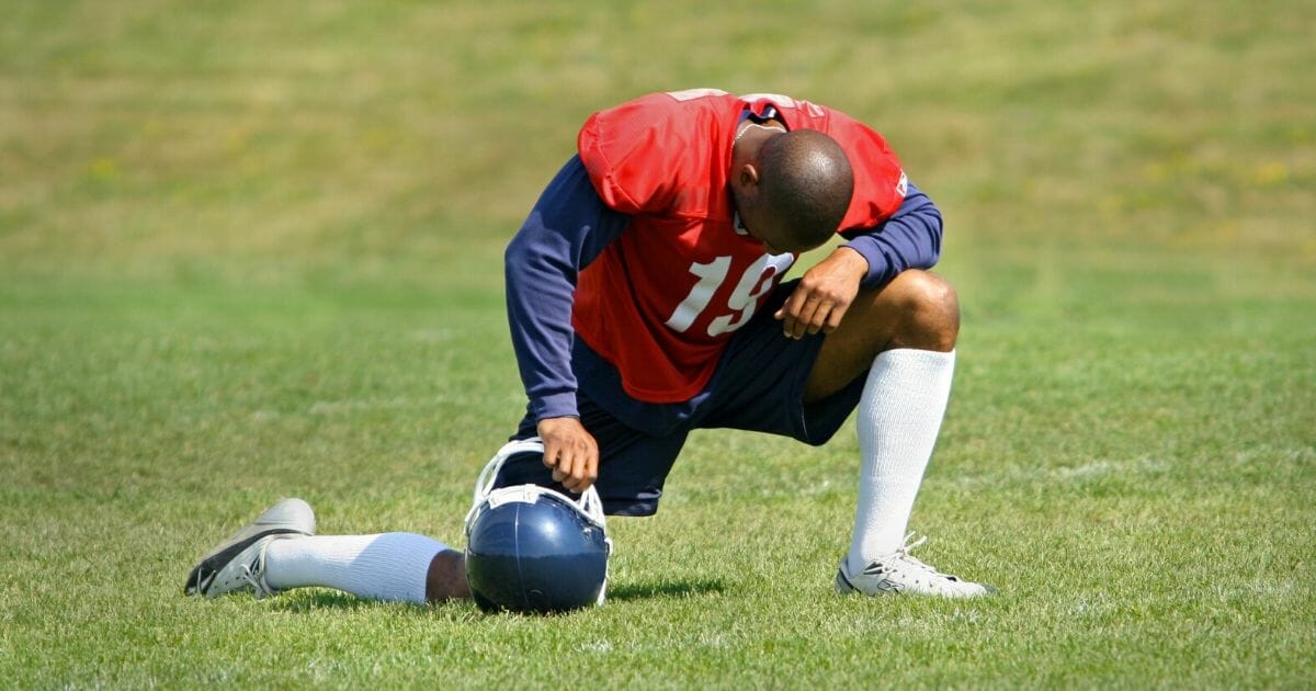 A football player down on one knee.