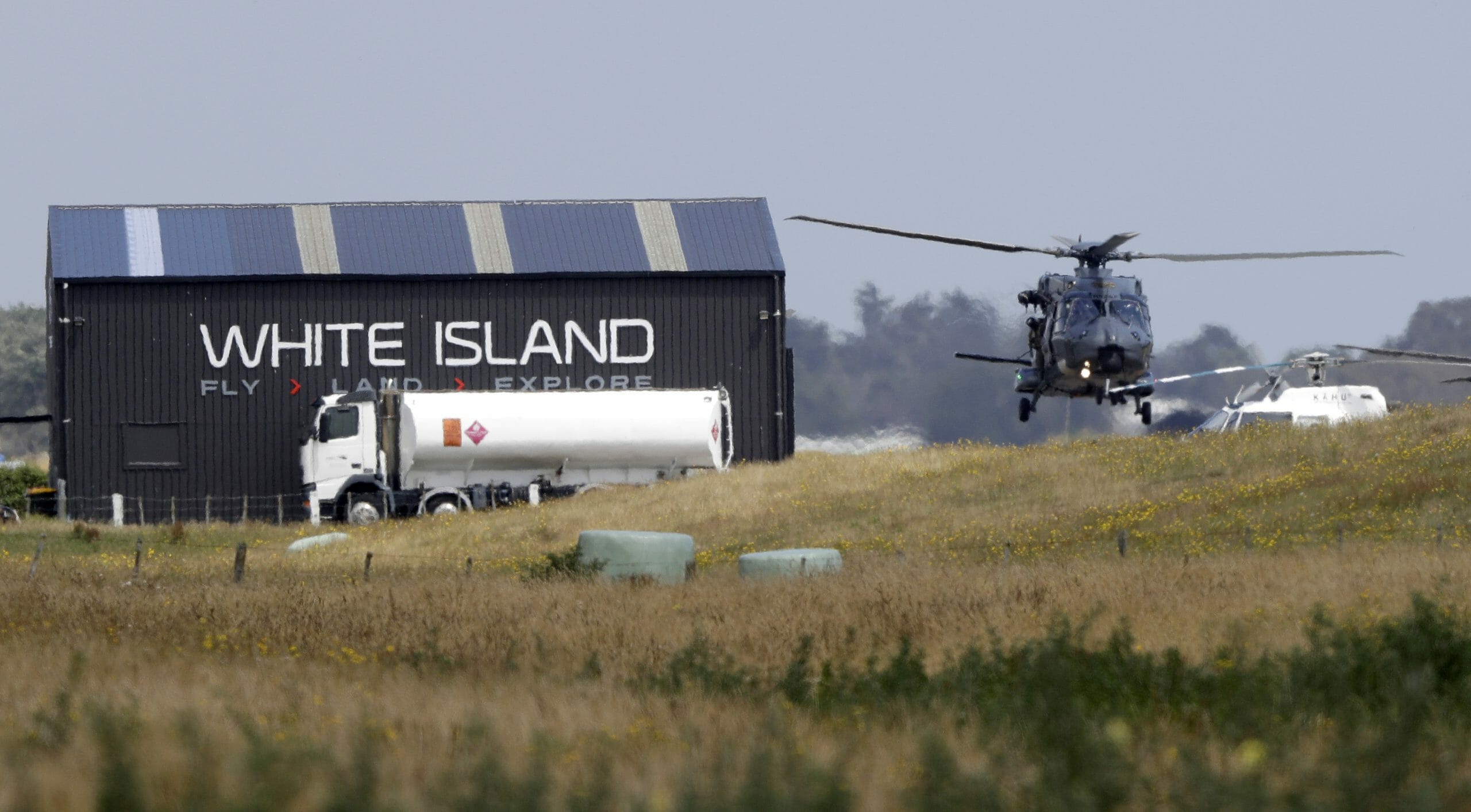 A Navy helicopter returns to Whakatane Airport following the recovery operation to return the victims of the Dec. 9 volcano eruption continues off the coast of Whakatane New Zealand, Friday, Dec. 13, 2019.
