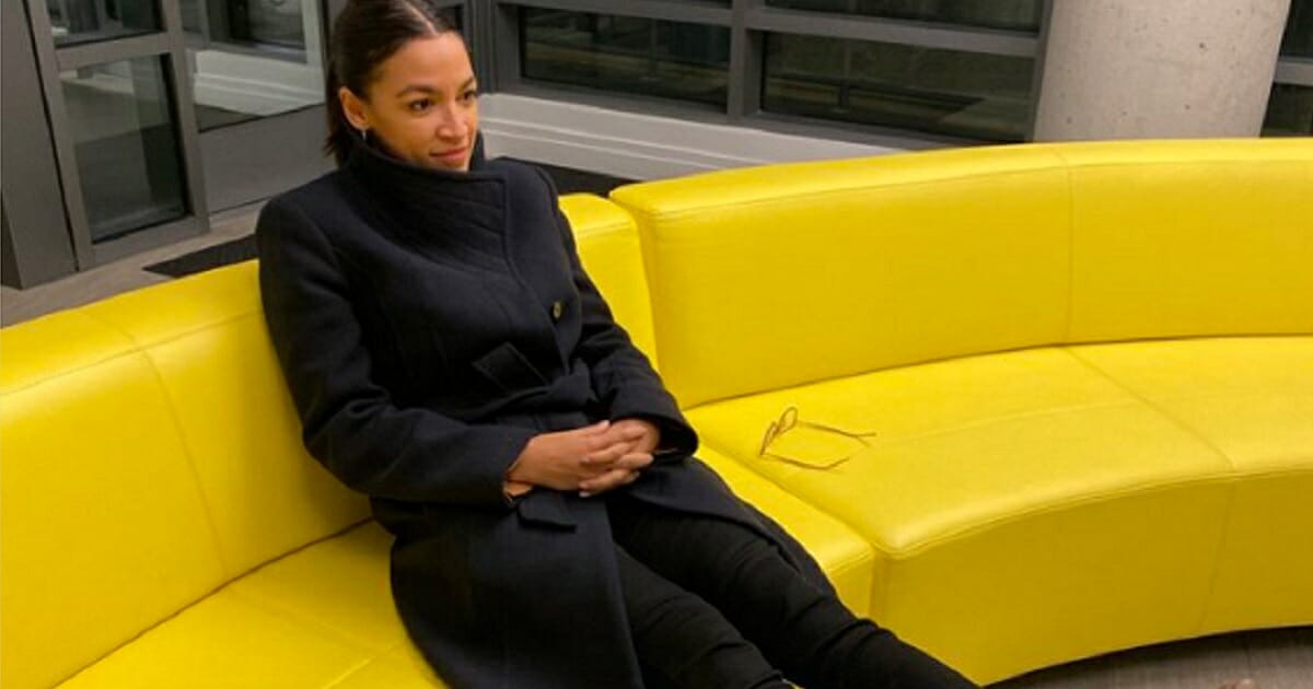 Rep. Alexandria Ocasio-Cortez sitting on a couch.