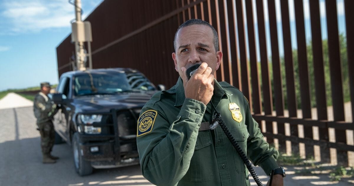 U.S. Border Patrol agent Carlos Ruiz spots a pair of undocumented immigrants while coordinating with active duty U.S. Army soldiers near the U.S.-Mexico border fence on Sept. 10, 2019, in Penitas, Texas.