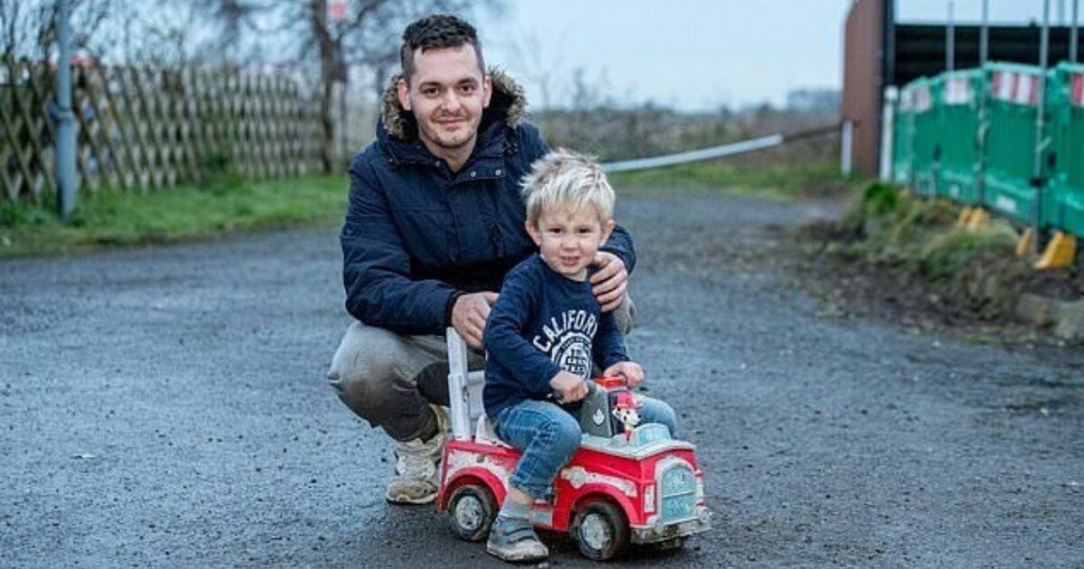 Boy on toy truck with dad