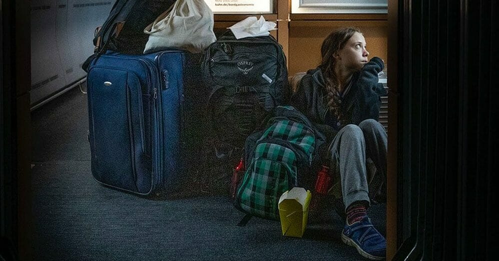 Greta Thunberg sitting on floor of train