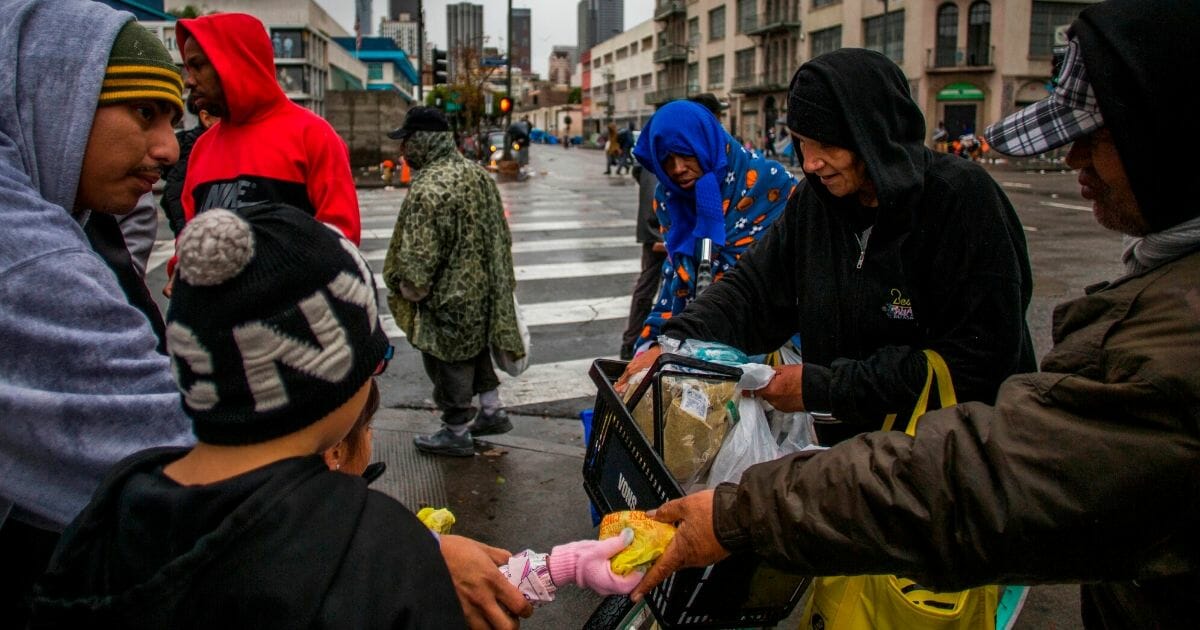 Volunters give food to homeless people in Los Angeles' Skid Row on Nov. 28, 2019.