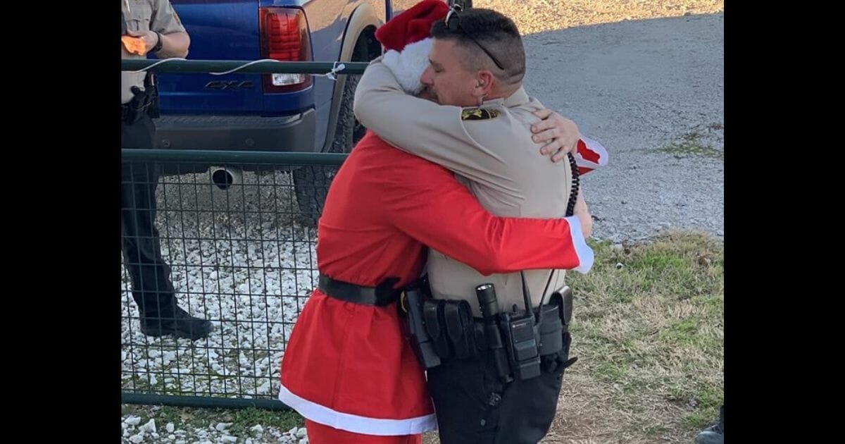 Marine Chris Kirk, dressed as Santa Claus, hugs his father, Deputy Chad Kirk of Denton County, Texas.