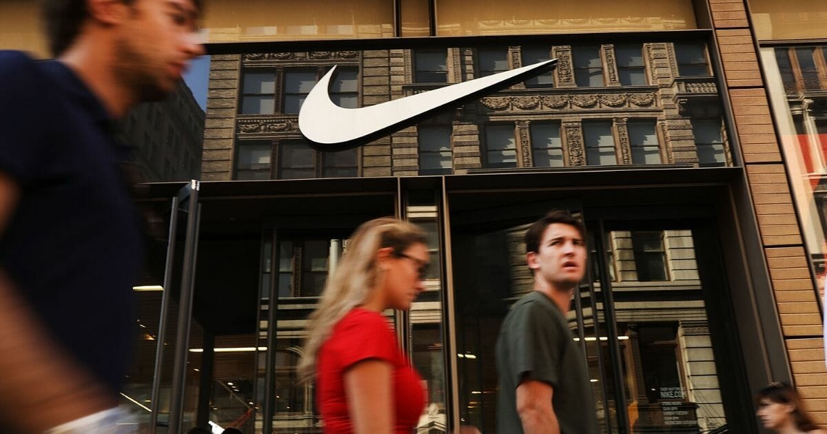 People walk by a Nike store in New York on Sept. 5, 2018.