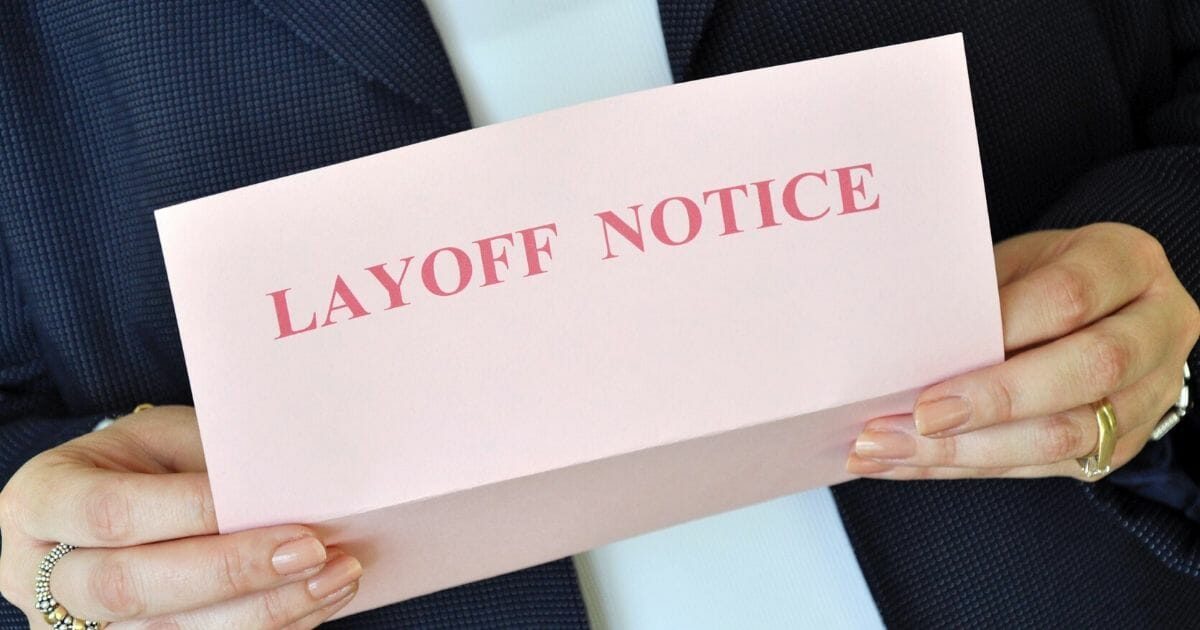 Female executive reading a layoff notice from her employer.