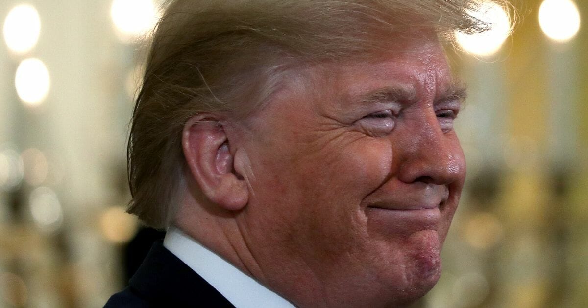 President Donald Trump smiles during a Hanukkah reception in the East Room of the White House on Dec. 11, 2019.