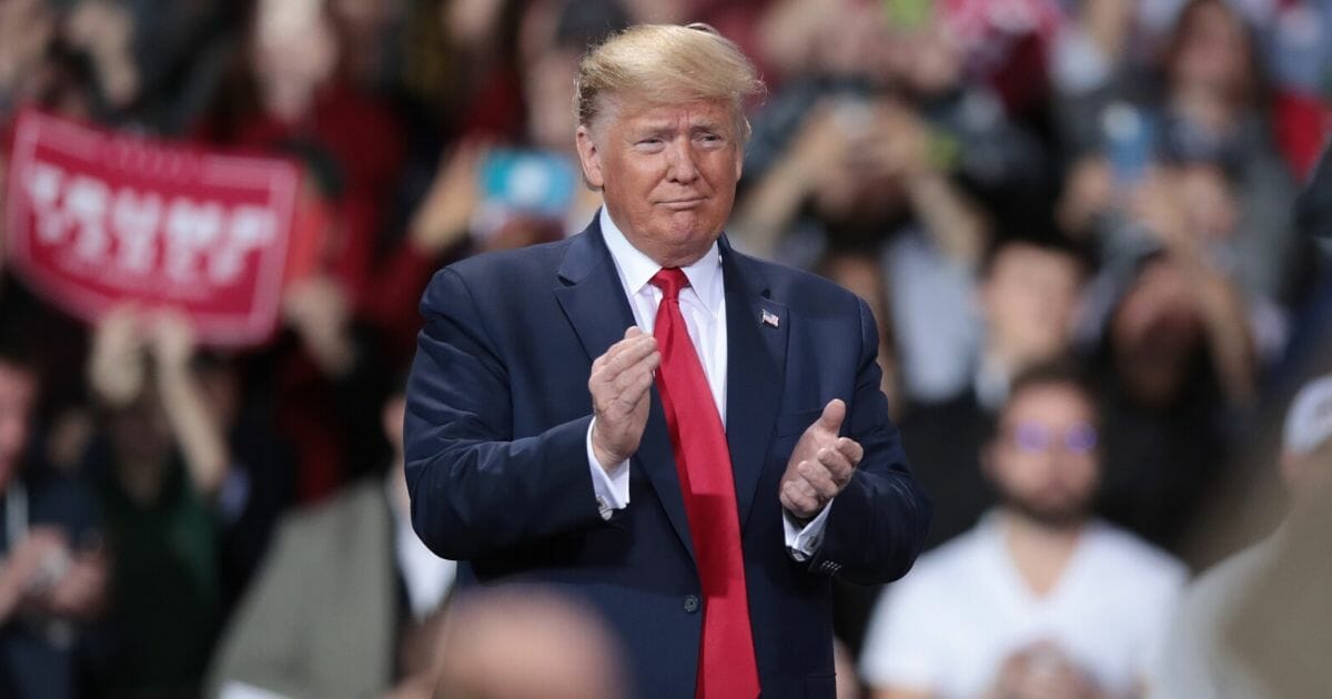 President Donald Trump claps during a rally at the Kellogg Arena in Battle Creek, Michigan, on Dec. 18, 2019.