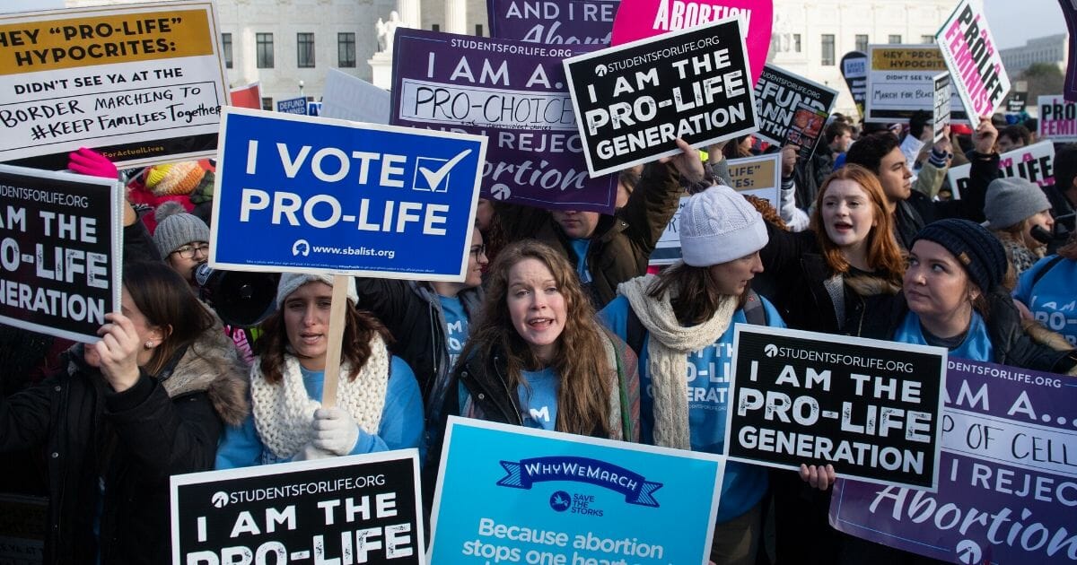 Pro-abortion activists hold signs in response to pro-life activists participating in the "March for Life," an annual event to mark the anniversary of the 1973 Supreme Court case Roe v. Wade, which legalized abortion in the U.S., outside the Supreme Court in Washington, D.C., on Jan. 18, 2019.