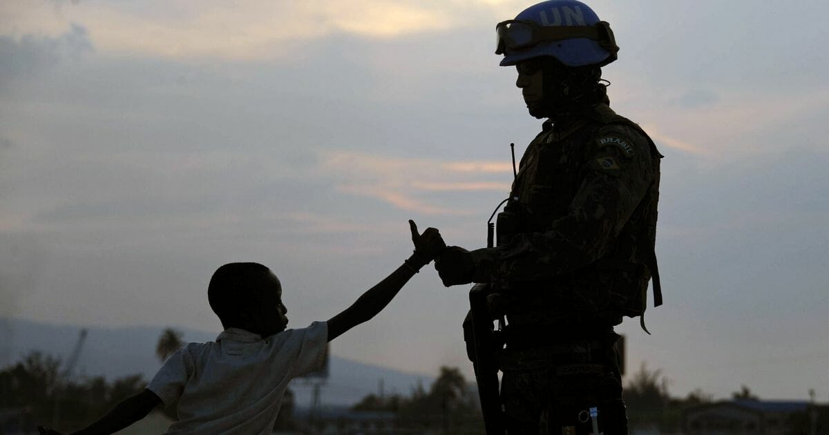 A Brazilian soldier with the MINUSTAH force greets a boy at a shantytown in Port-au-Prince on March 2, 2013.