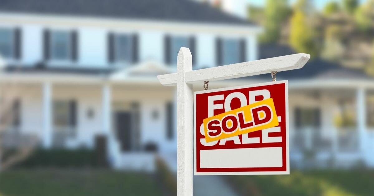 Stock image of a "home sold" sign in front of a house.