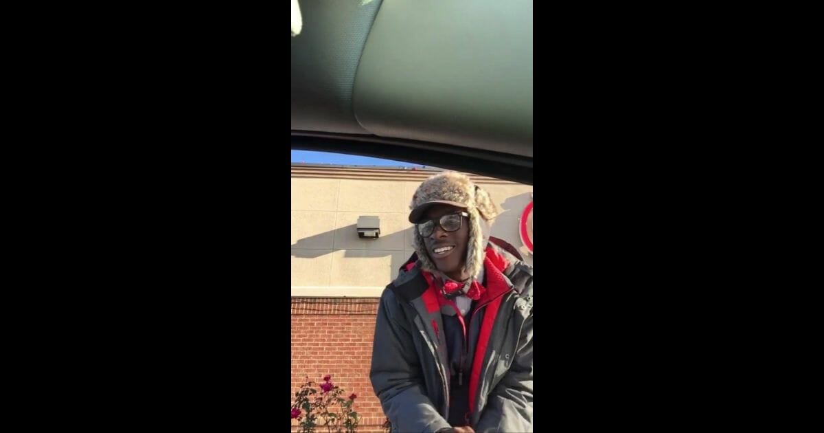 Chick-fil-A employee Jeremiah Murrrill takes a customer's order in the drive-thru line.