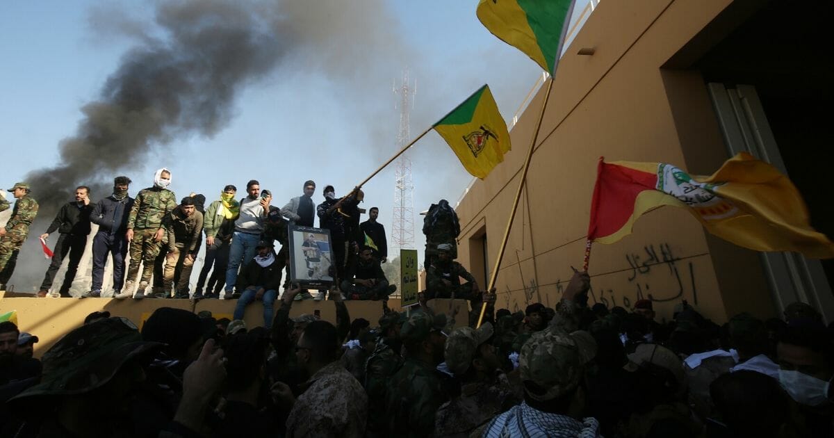 Smoke billows from a burning guard building at the entrance of the U.S. Embassy in Baghdad as thousands of Iraqi protesters breach the outer wall of the embassy grounds on Tuesday.