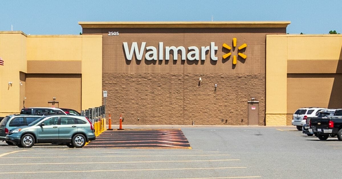 A Walmart Superstore and the parking lot with cars.