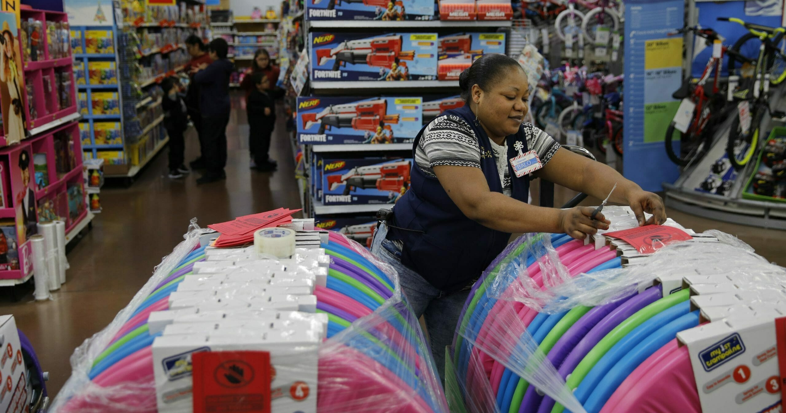 In this Nov. 27, 2019, file photo, Balo Balogun labels items in preparation for a holiday sale at a Walmart Supercenter in Las Vegas.