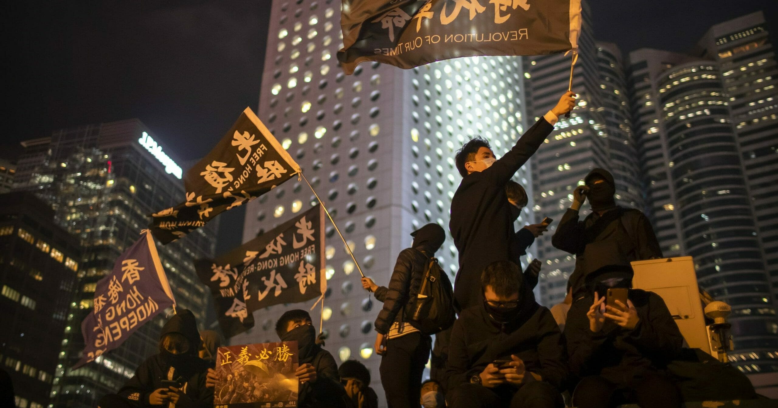 A protestor holds a flag that reads: "Liberate Hong Kong, Revolution of Our Times" at a rally in Hong Kong, Thursday, Dec. 12, 2019.