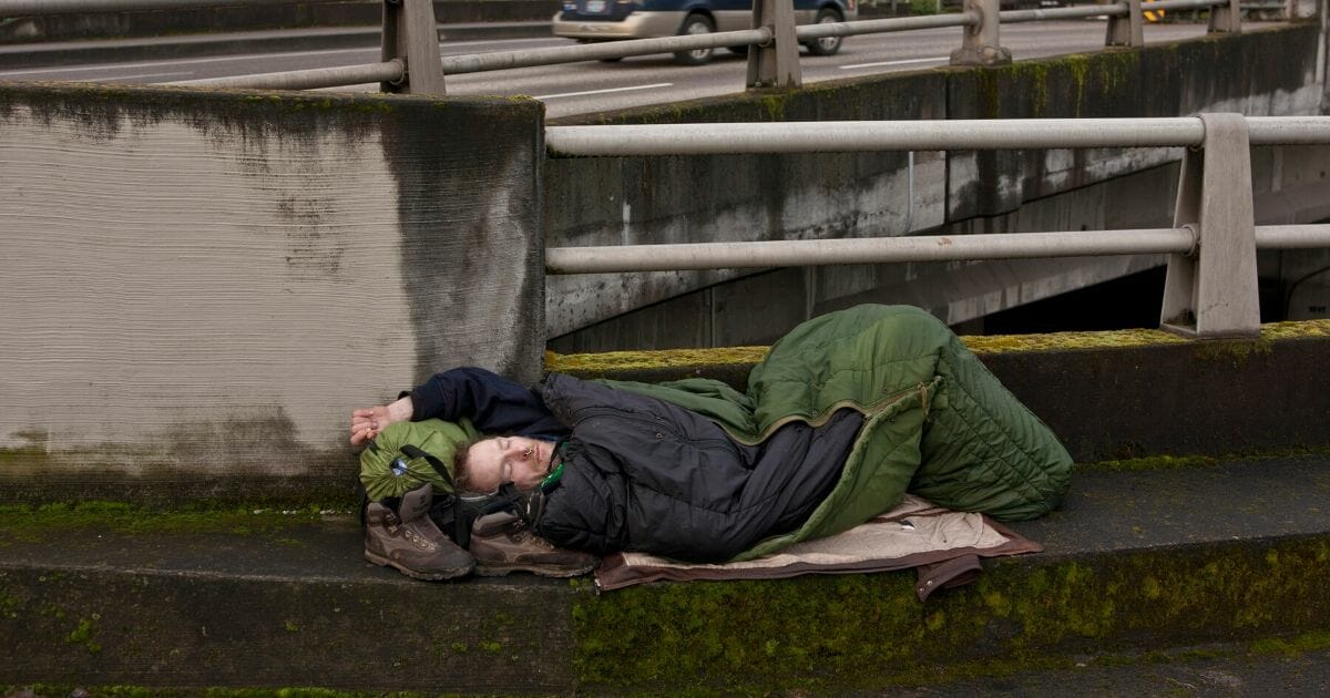 A homeless man sleeps on a downtown roadway overpass on Feb. 11, 2012, in Portland, Oregon.