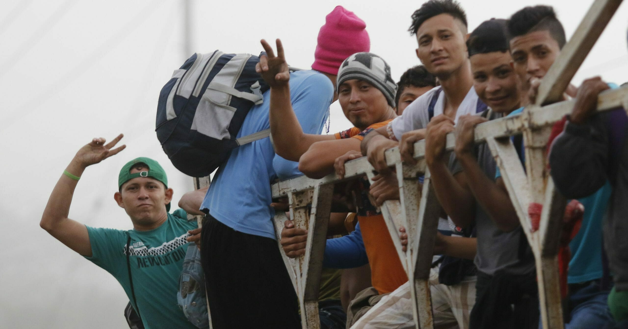 Migrants ride on top of a truck moving along the highway, in hopes of reaching the distant United States, from San Pedro Sula, Honduras, on Jan. 15, 2020. Hundreds of Honduran migrants started walking and hitching rides Wednesday from the city of San Pedro Sula, in a bid to form the kind of migrant caravan that reached the U.S. border in 2018.