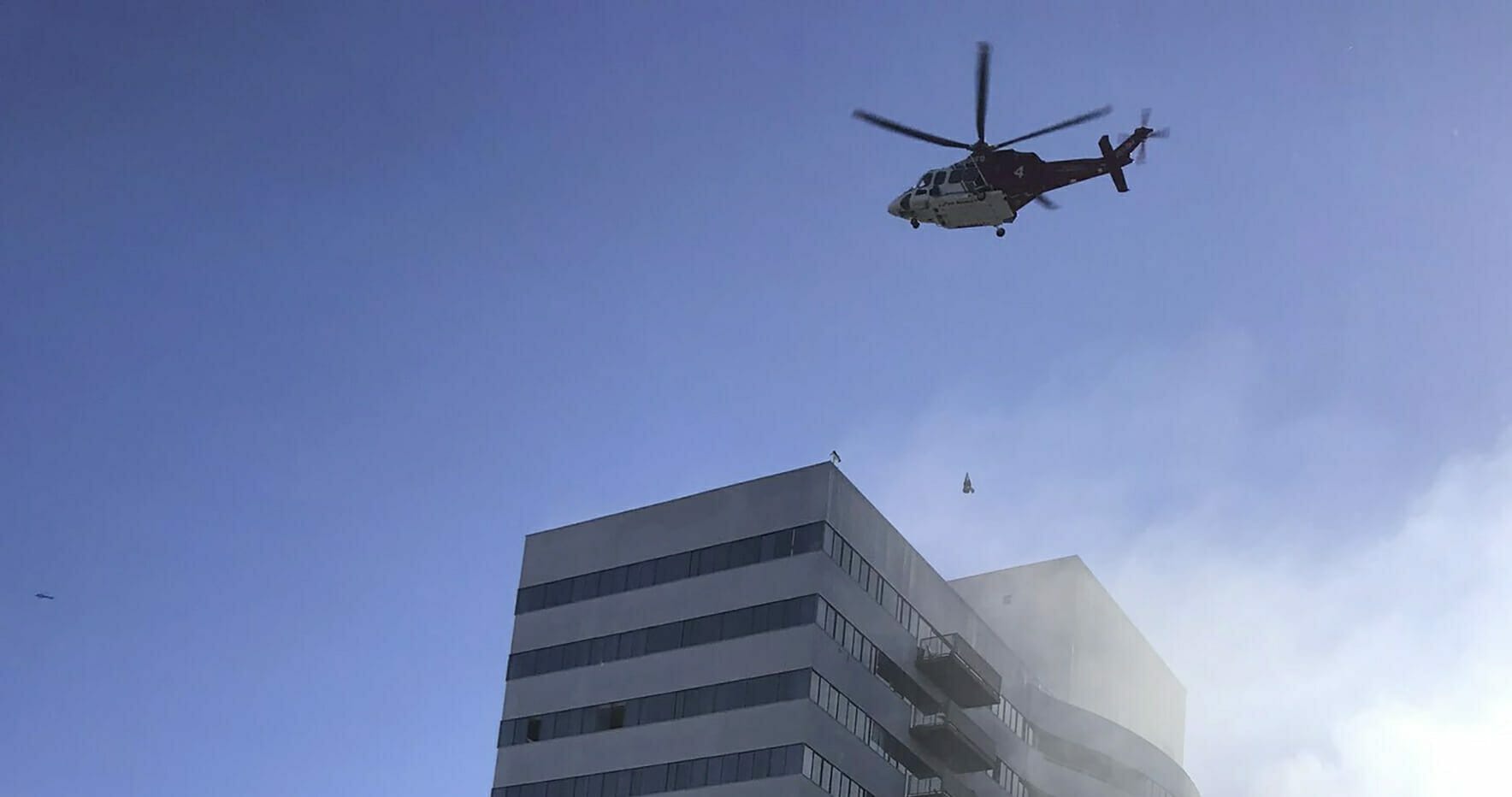 A helicopter flies over a residential building on fire in Los Angeles on Jan. 29, 2020.
