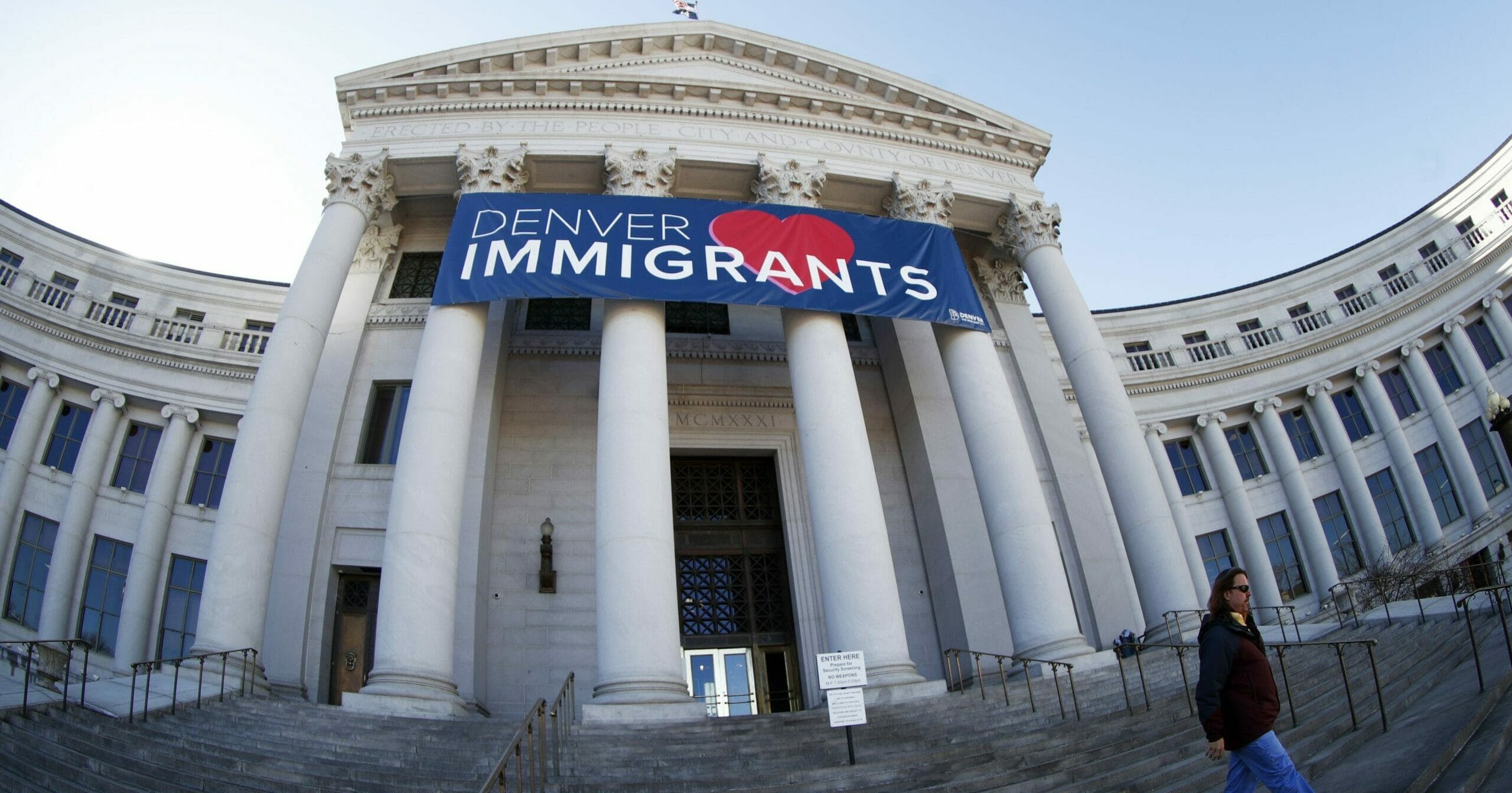 In this Feb. 26, 2018, file photo, a banner to welcome immigrants is viewed through a fisheye lens over the main entrance to the Denver City and County Building in Denver. U.S. Immigration and Customs Enforcement has subpoenaed Denver law enforcement for information on four foreign nationals wanted for deportation and could expand the unusual practice to other cities, an escalation of the conflict between federal officials and so-called sanctuary cities.