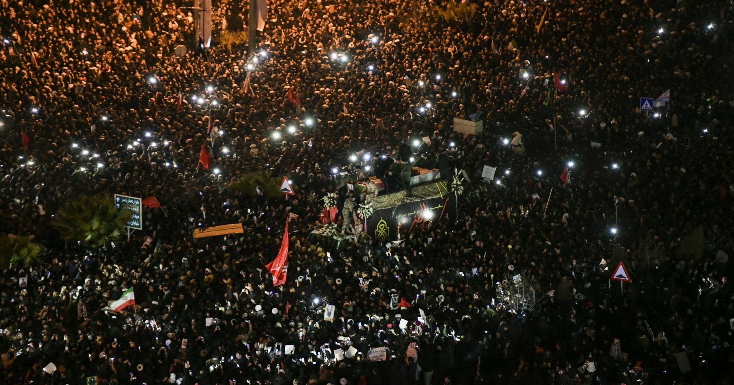 Iranians surround a truck carrying the flag-draped coffins of Gen. Qassem Soleimani and his comrades in the city of Qom, south of Tehran, on Jan. 6, 2020.