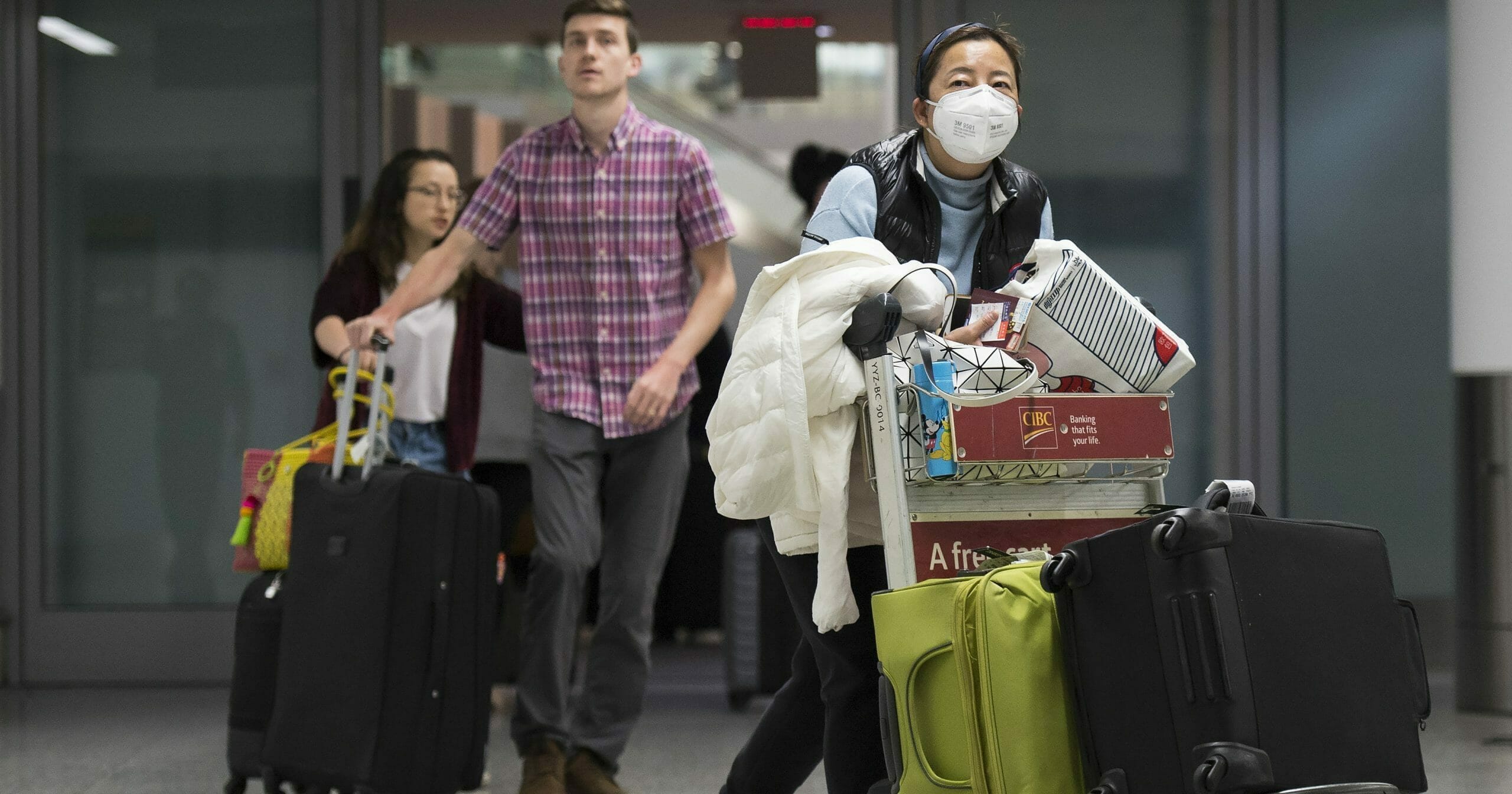 A woman wears a mask following the outbreak of coronavirus as people arrive from the International terminal at Toronto Pearson International Airport on Jan. 25, 2020.