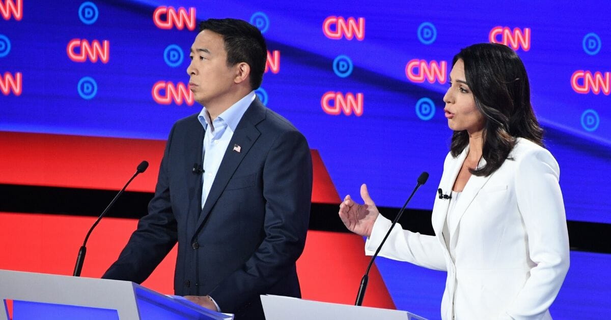 Democratic presidential hopefuls entrepreneur Andrew Yang, left, and Rep. Tulsi Gabbard of Hawaii speak during the second round of the second Democratic primary debate of the 2020 presidential campaign season hosted by CNN at the Fox Theatre in Detroit, Michigan, on July 31, 2019.