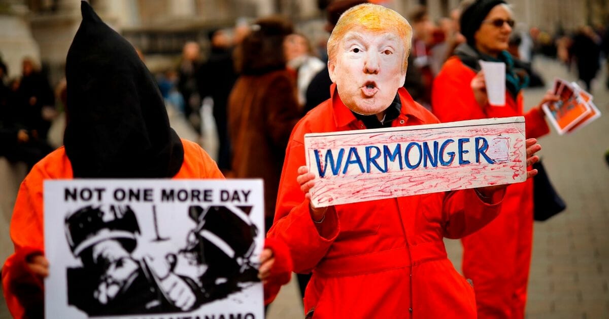 A protester holds up a placard, dressed as President Donald Trump during a demonstration against the threat of war on Iran, in central London on Jan. 11, 2020.