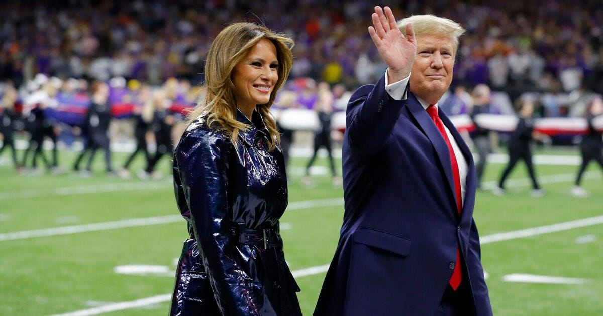 First lady Melania Trump, left, and President Donald Trump wave prior to the College Football Playoff National Championship game between the Clemson Tigers and the LSU Tigers at the Mercedes Benz Superdome on Jan. 13, 2020, in New Orleans, Louisiana.