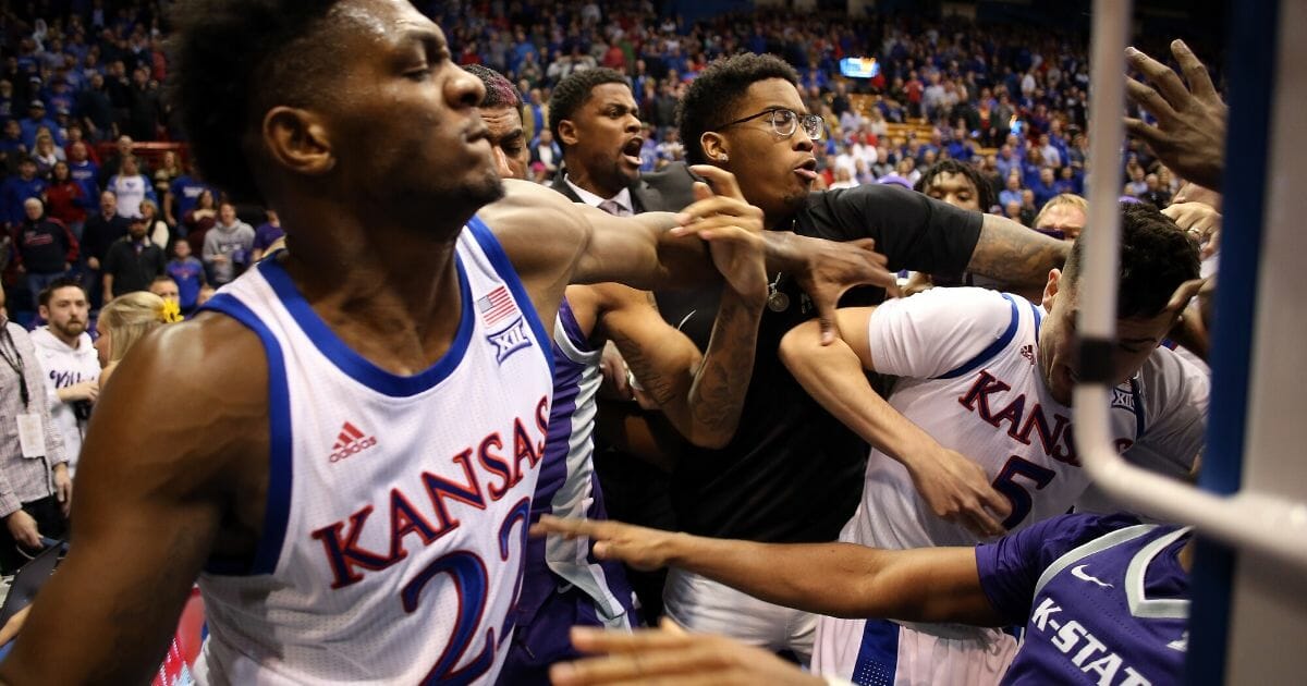 James Love III of the Kansas State Wildcats grabs Elijah Elliott (No. 5) of the Kansas Jayhawks and Silvio De Sousa (No. 22) during a brawl after the game at Allen Fieldhouse in Lawrence, Kansas, on Jan. 21, 2020