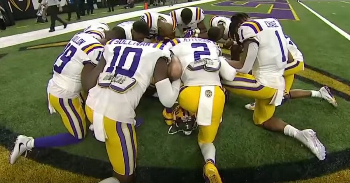 LSU players kneel in prayer prior to the College Football Playoff national championship Monday night.