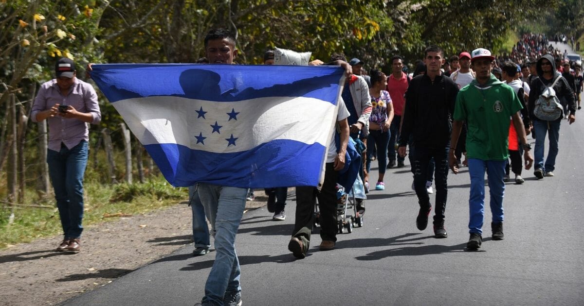 Honduran migrants walk with a Honduran flag near Esquipulas, Chiquimula department, Guatemala, on Jan. 16, 2020, after crossing the border in Agua Caliente from Honduras on their way to the U.S.
