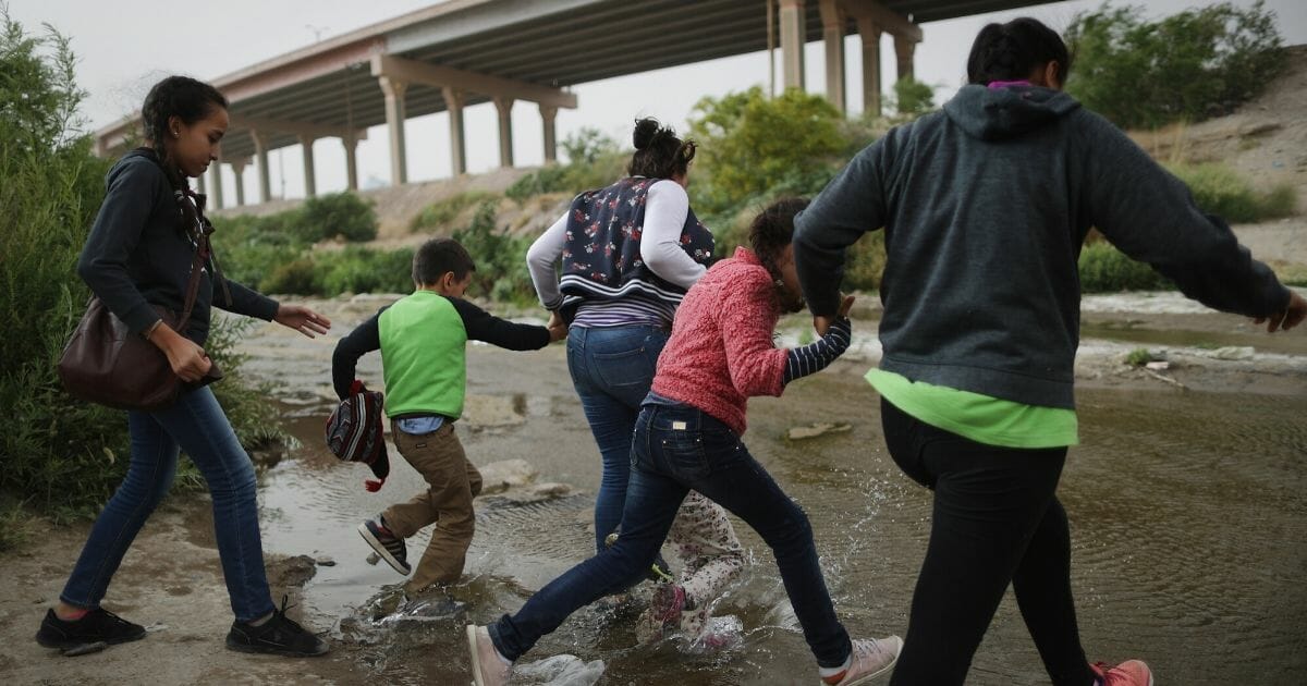 Migrants make their way to cross the border between the U.S. and Mexico at the Rio Grande river, on their way to enter El Paso, Texas, on May 20, 2019, as taken from Ciudad Juarez, Mexico.