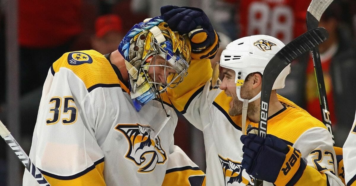 Pekka Rinne of the Nashville Predators celebrates a win against the Chicago Blackhawks and his first career goal, an empty net shot, with Rocco Grimaldi at the United Center in Chicago on Jan. 9, 2020. The Predators defeated the Blackhawks 5-2.