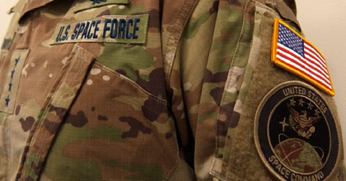 Photo of camouflage shirt with Space Force insignia.