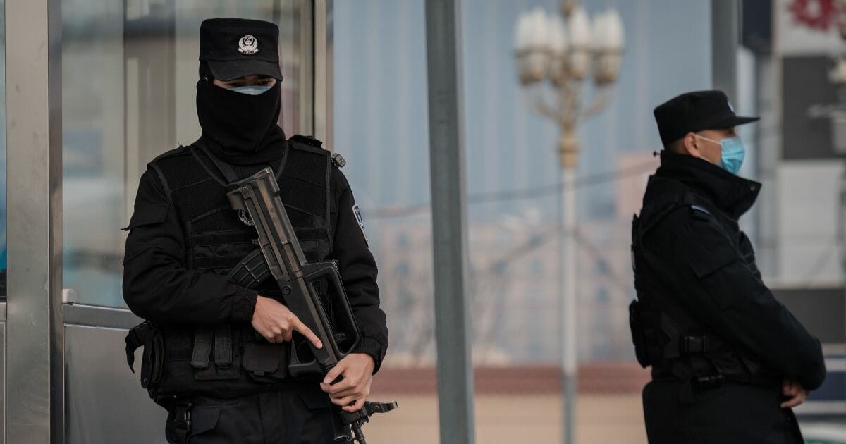 Police officers wearing protective facemasks to help stop the spread of a deadly virus that began in Wuhan, China, secure an area at the Beijing railway station Jan. 27, 2020.